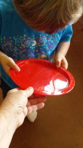 Teacher handing Transition Object (plate) to student